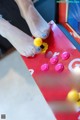 A person playing a game of pinball on a red arcade machine.