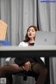 A woman sitting at a desk with a laptop computer.