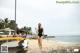 A woman in a black bathing suit standing on a beach.