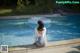 A woman sitting on the edge of a swimming pool.