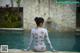 A woman sitting on the edge of a swimming pool.