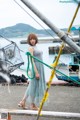 A woman standing on a dock next to a boat.