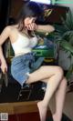 A woman sitting on top of a chair next to a pinball machine.