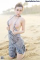 A woman in a leopard print dress on the beach.