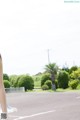 A woman standing in the middle of a parking lot.