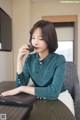 A woman sitting at a table with a cup of coffee.