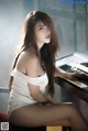 A woman sitting at a piano in a white dress.