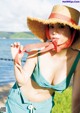 A woman in a straw hat is posing for a picture.