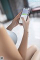 A woman sitting on a couch holding a cell phone.