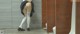 A woman in white stockings and high heels standing in a public restroom.