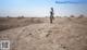 A man standing on top of a dirt field.