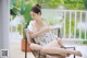 a woman sitting on top of a chair next to a pool