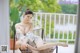 A woman sitting on a chair on a balcony.