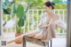 A woman sitting on a chair with her legs crossed.