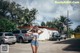 A woman in a blue and white bikini standing in a parking lot.